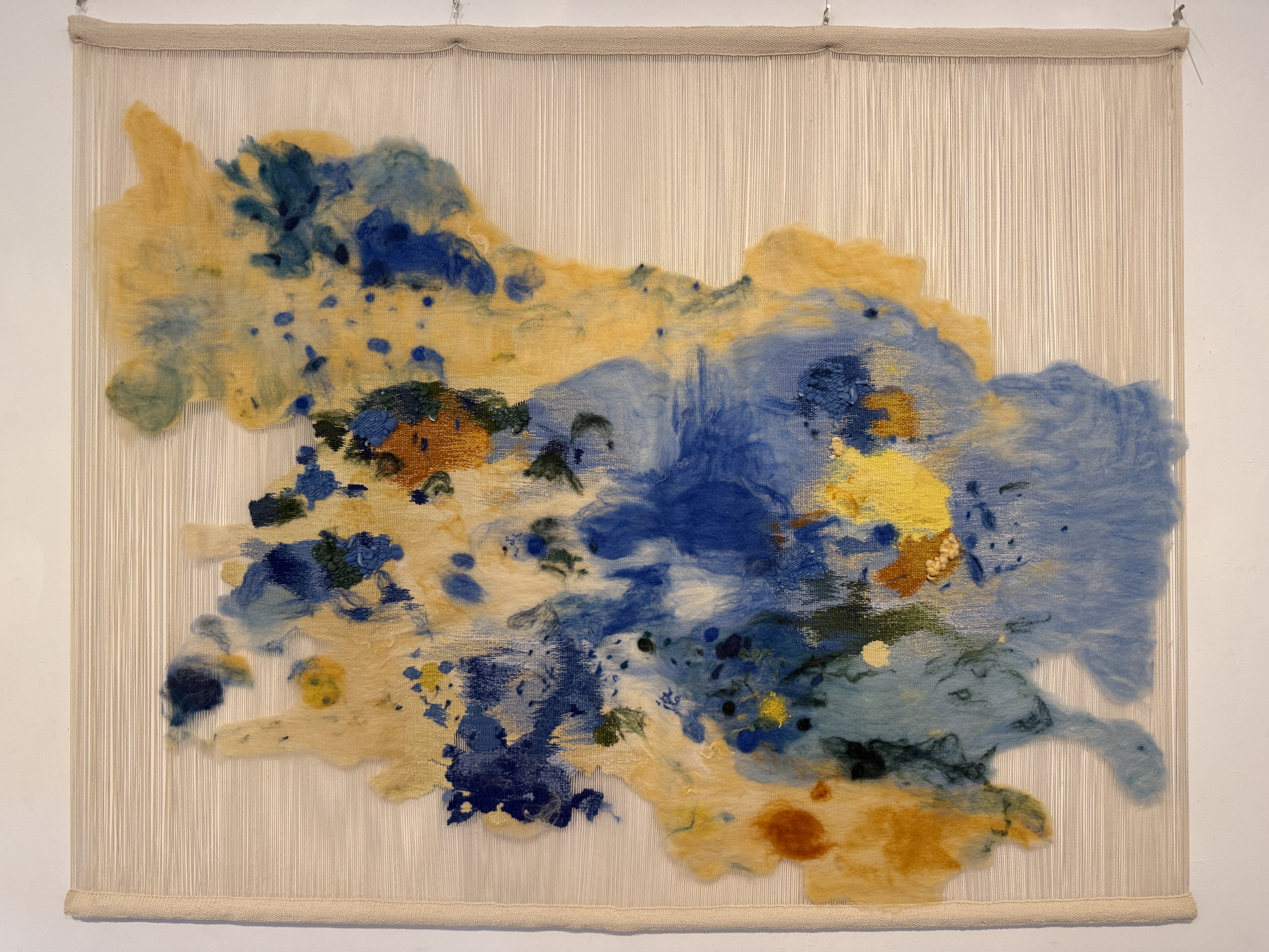 Œuvre textile avec des tons bleus et jaunes